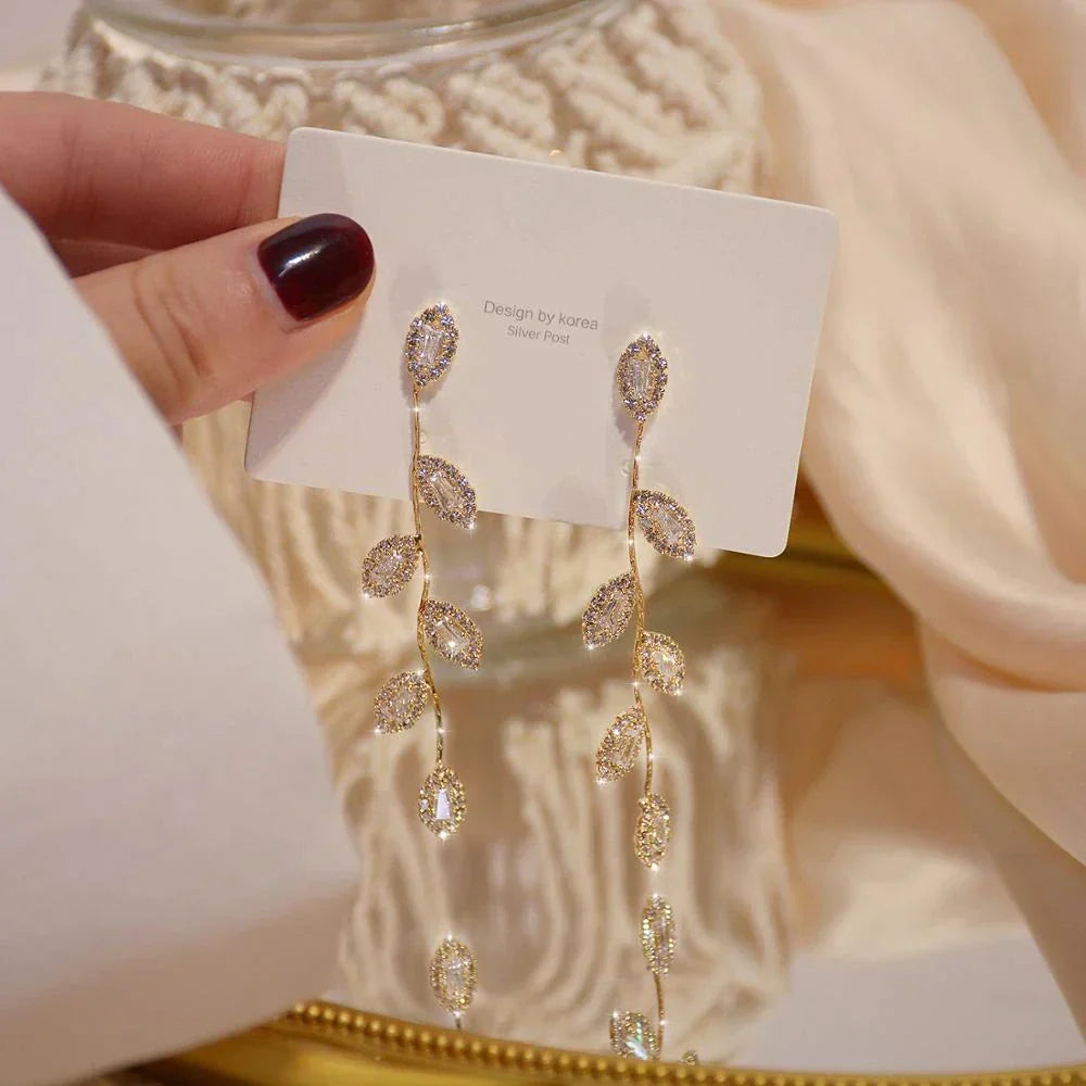 Boucles d'oreilles longues avec de délicates feuilles dorées
