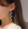 Boucles d'oreilles longues avec de délicates feuilles dorées