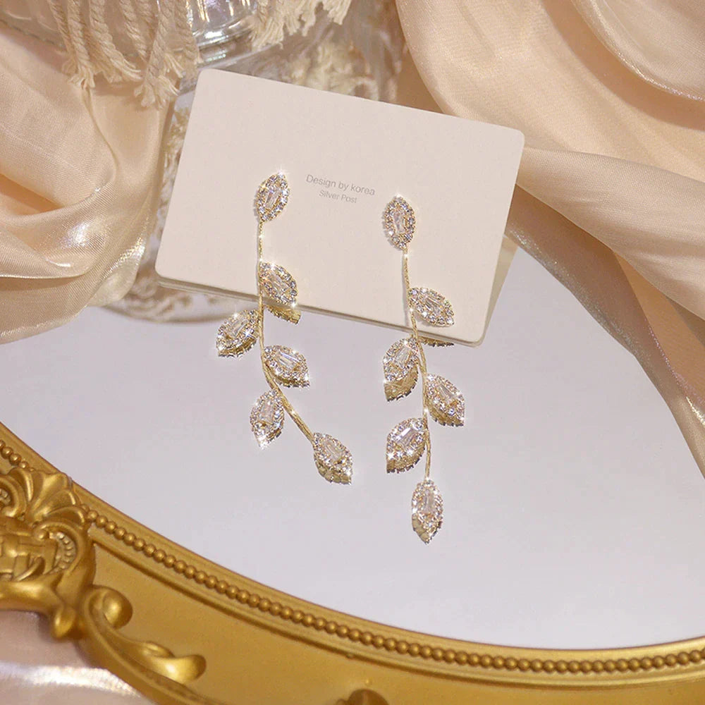 Boucles d'oreilles longues avec de délicates feuilles dorées