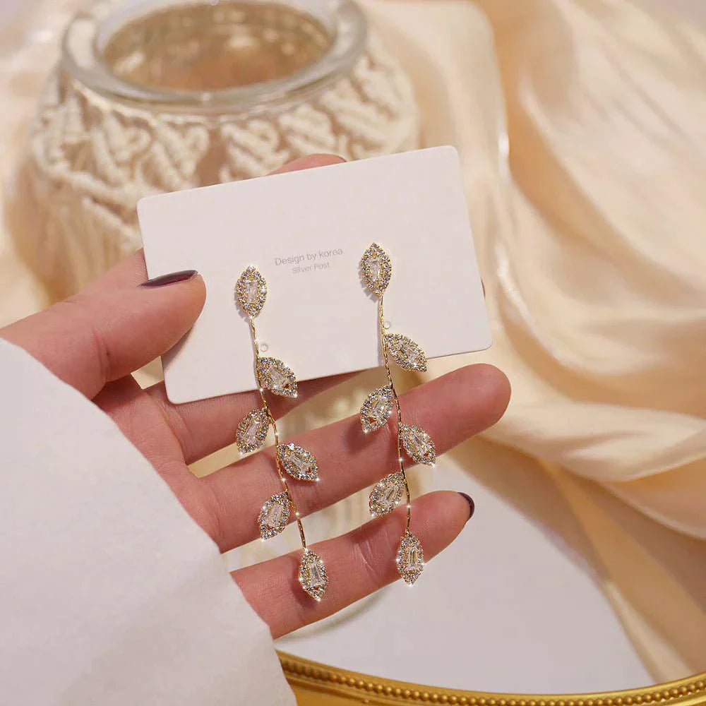 Boucles d'oreilles longues avec de délicates feuilles dorées