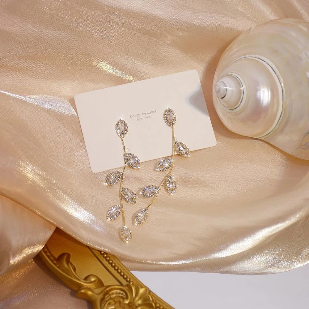 Boucles d'oreilles longues avec de délicates feuilles dorées
